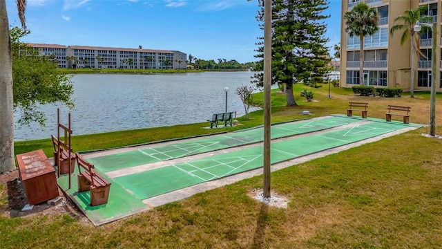 view of property's community featuring shuffleboard, a yard, and a water view