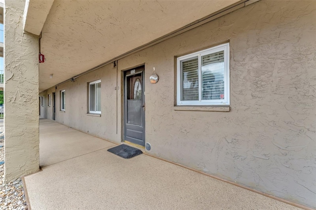 property entrance featuring a patio and stucco siding