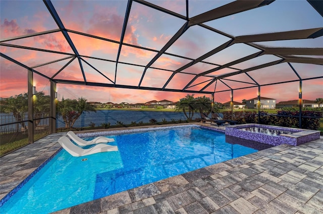 view of swimming pool featuring a lanai, a pool with connected hot tub, and a patio