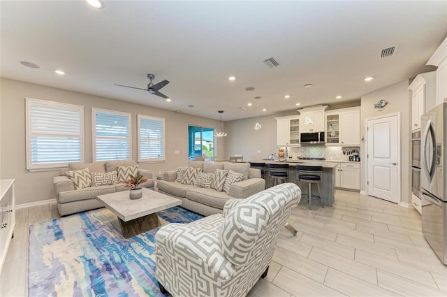 living area featuring visible vents, recessed lighting, baseboards, and ceiling fan