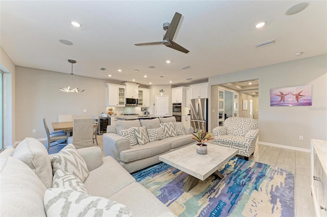 living area featuring recessed lighting, visible vents, and baseboards