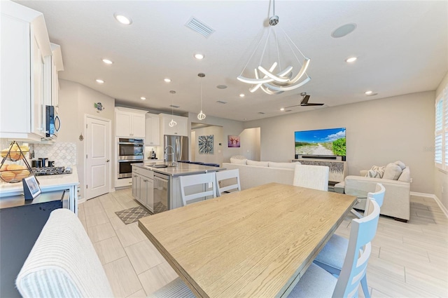 dining space with an inviting chandelier, recessed lighting, visible vents, and baseboards