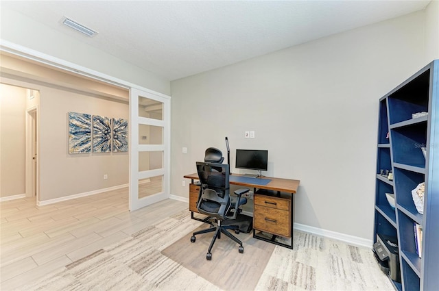 office space with visible vents, french doors, baseboards, and wood finished floors