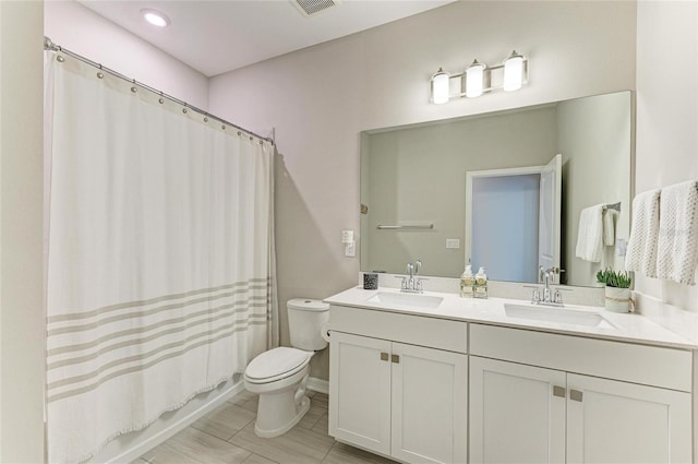 full bathroom with double vanity, toilet, shower / tub combo, and a sink