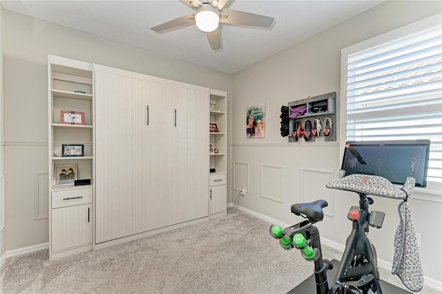 workout area with a ceiling fan and carpet flooring