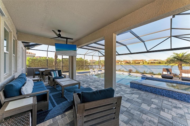 view of patio / terrace with a water view, a pool with connected hot tub, glass enclosure, outdoor lounge area, and ceiling fan