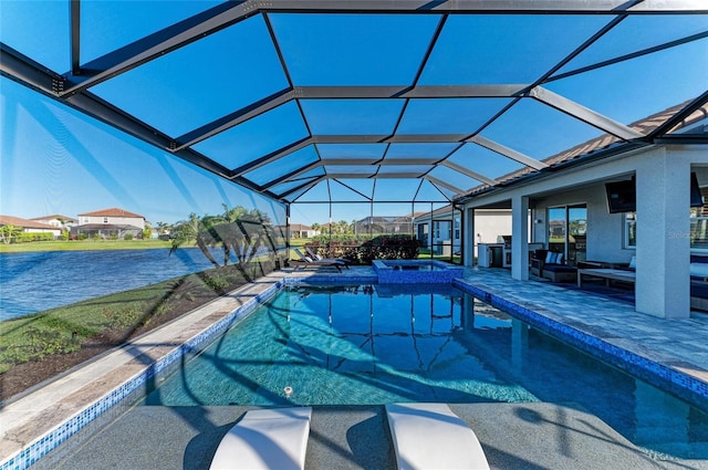 view of swimming pool featuring glass enclosure, a patio, a water view, and a pool with connected hot tub