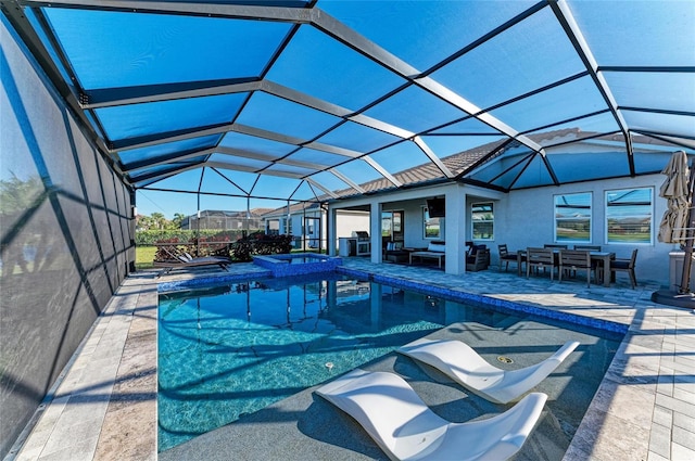 view of swimming pool featuring a patio area, glass enclosure, and a pool with connected hot tub