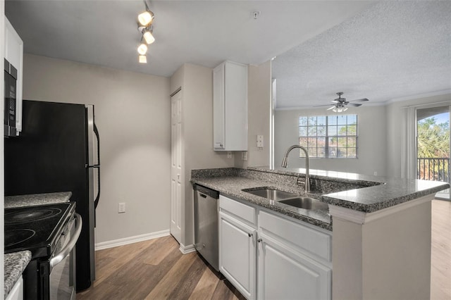 kitchen featuring black / electric stove, a peninsula, a sink, light wood-style floors, and stainless steel dishwasher