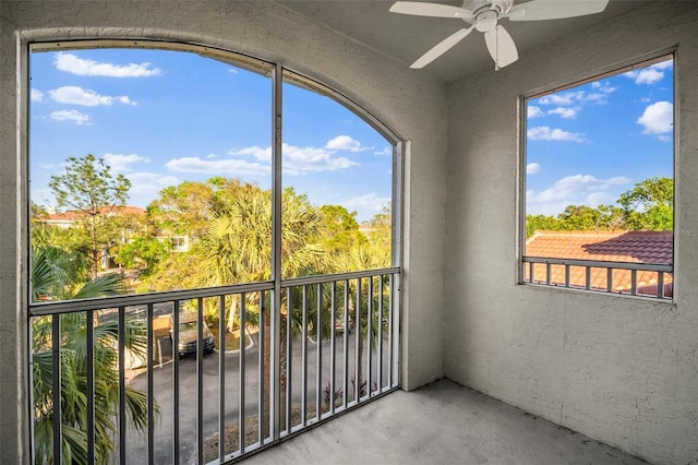 unfurnished sunroom with ceiling fan