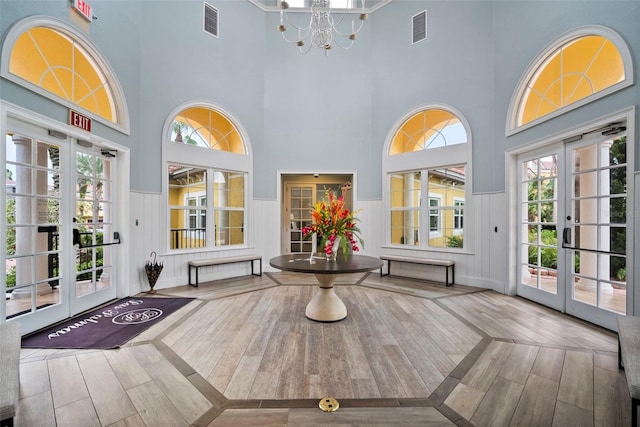 unfurnished sunroom featuring visible vents, a chandelier, and french doors