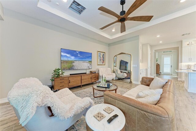 living area with recessed lighting, a raised ceiling, visible vents, a ceiling fan, and light wood-type flooring