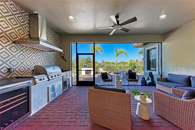 view of patio / terrace with wine cooler, area for grilling, an outdoor living space, and a ceiling fan