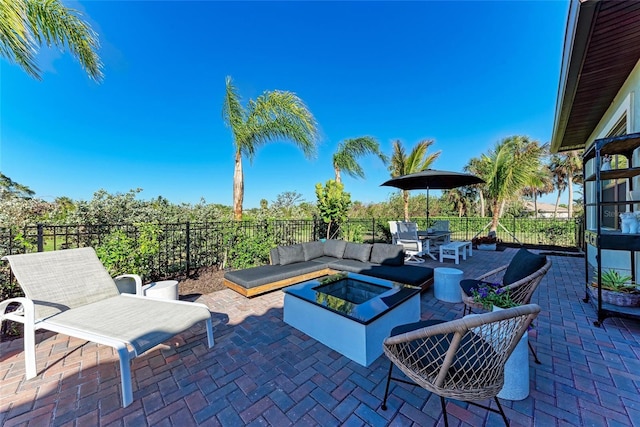 view of patio with an outdoor living space with a fire pit and fence