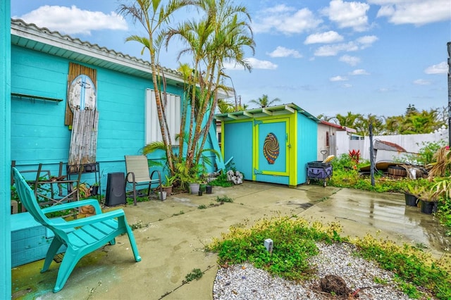 256 144th Ave, Madeira Beach, FL 33708 - view of patio with fence, an outbuilding, and a storage unit