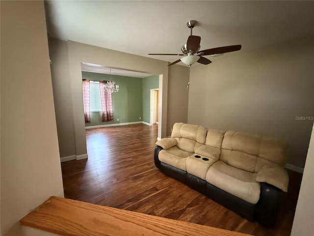 living room featuring baseboards, wood finished floors, and ceiling fan with notable chandelier