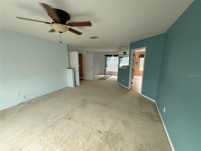 unfurnished living room with ceiling fan, visible vents, baseboards, and light colored carpet