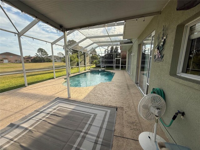 view of pool featuring glass enclosure, a yard, a patio area, and a pool with connected hot tub