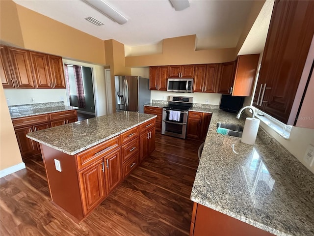 kitchen featuring stainless steel appliances, dark wood-style flooring, a kitchen island, a sink, and visible vents