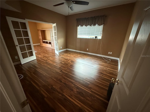 spare room featuring lofted ceiling, french doors, baseboards, and wood finished floors