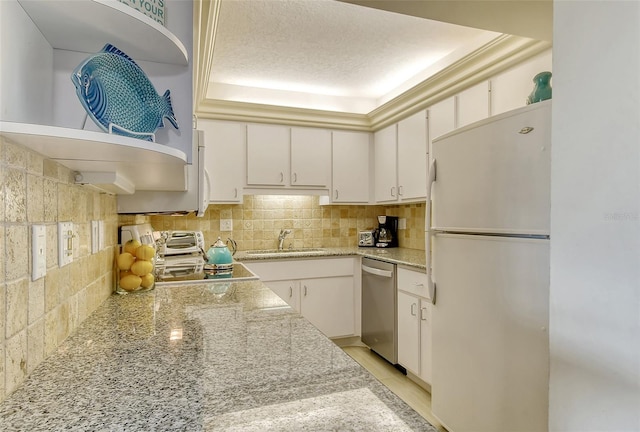 kitchen featuring freestanding refrigerator, a sink, dishwasher, open shelves, and white cabinets