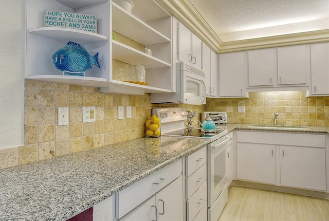 kitchen featuring white appliances, a sink, open shelves, and tasteful backsplash