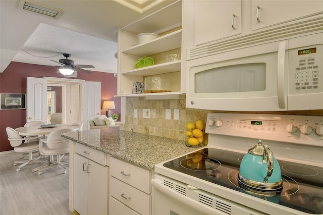 kitchen featuring white appliances, ceiling fan, tasteful backsplash, light stone countertops, and white cabinets