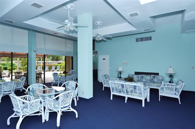 dining area featuring a raised ceiling, a ceiling fan, and carpet