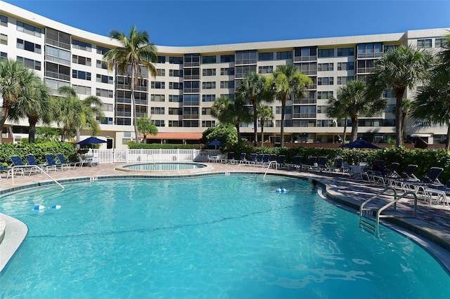 community pool with fence and a patio