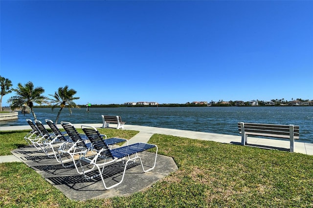 view of green lawn featuring a water view
