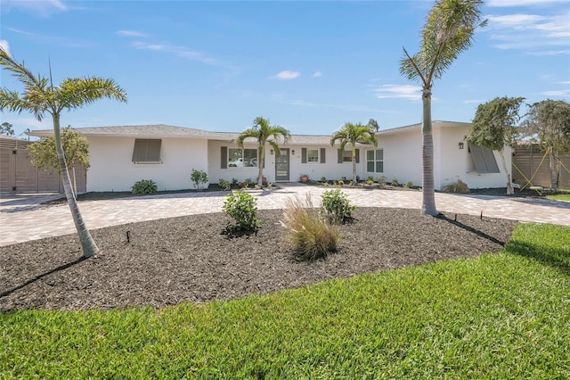 ranch-style house featuring decorative driveway and stucco siding