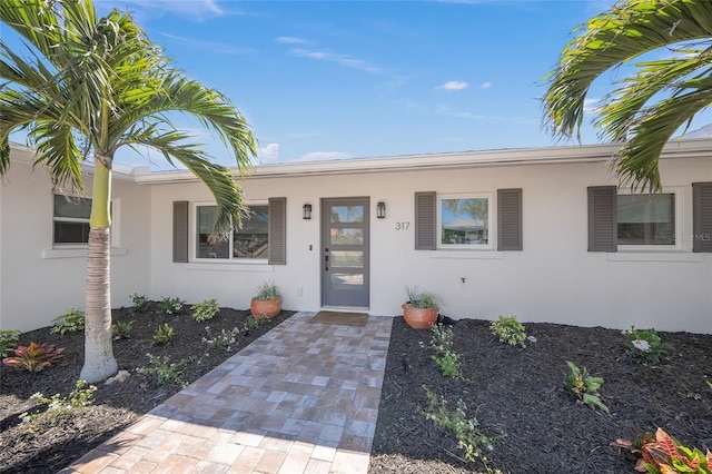 view of exterior entry with stucco siding