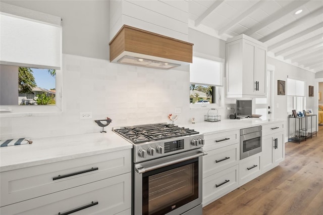 kitchen featuring white cabinets, light wood-style floors, tasteful backsplash, and stainless steel range with gas cooktop