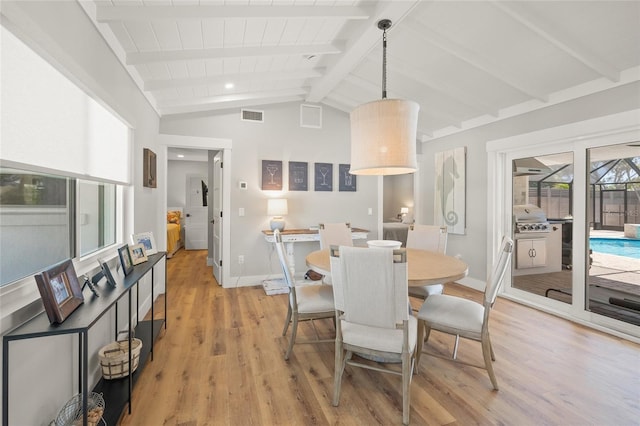 dining area featuring visible vents, baseboards, light wood-style floors, and vaulted ceiling with beams