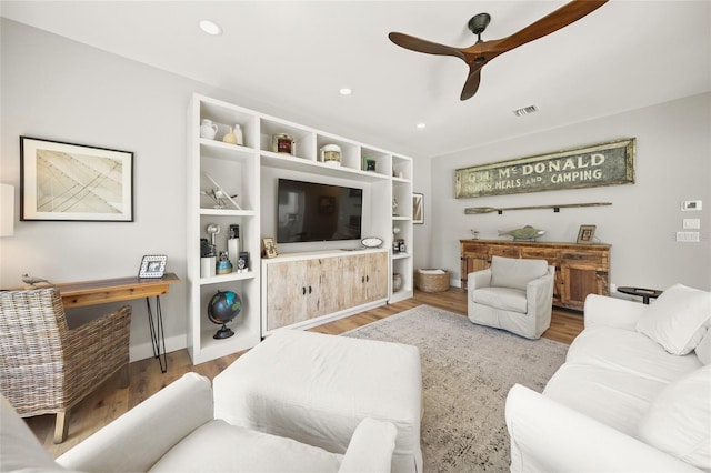 living area with a ceiling fan, recessed lighting, wood finished floors, and visible vents