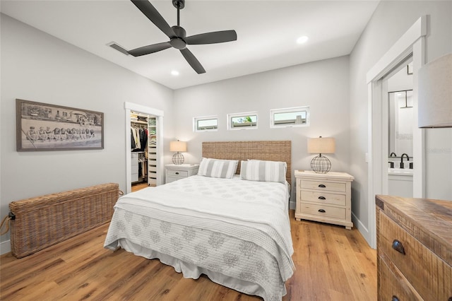 bedroom featuring light wood-style flooring, a spacious closet, recessed lighting, and a closet