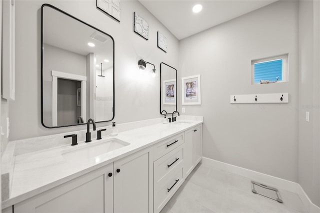 full bathroom featuring double vanity, recessed lighting, baseboards, and a sink