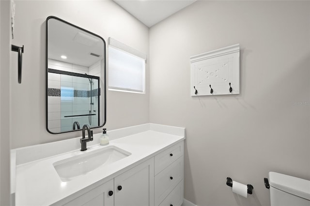 full bathroom featuring a shower stall, toilet, and vanity