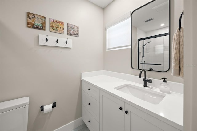 full bath with visible vents, toilet, a shower stall, baseboards, and vanity