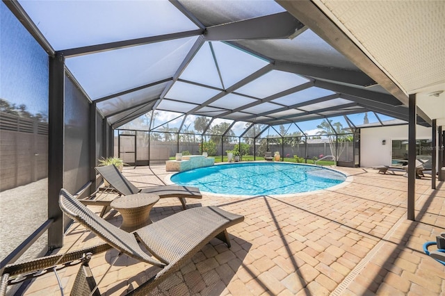 outdoor pool with a patio, a lanai, and fence