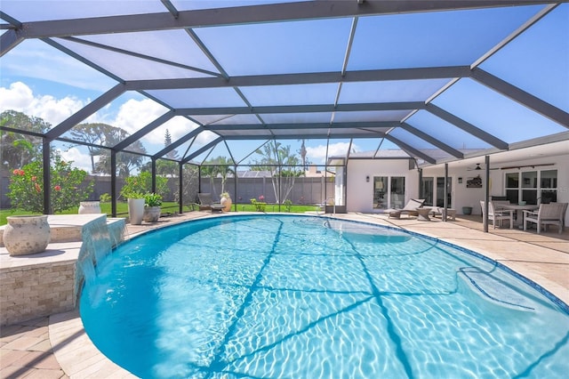 view of swimming pool featuring a fenced in pool, a patio, glass enclosure, and a ceiling fan