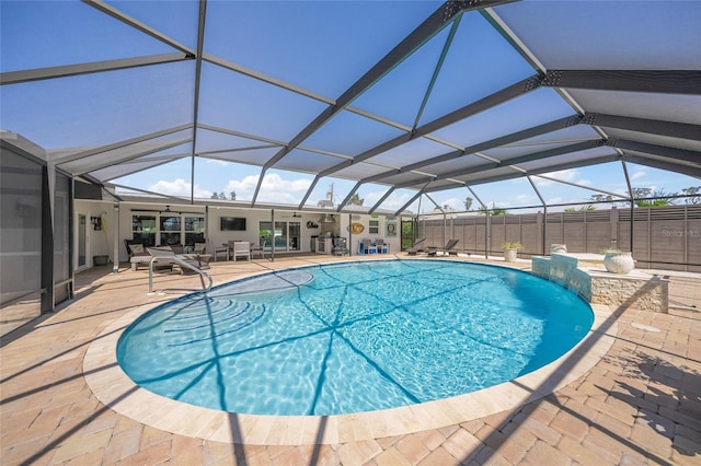 view of swimming pool with a patio, fence, a fenced in pool, and a lanai