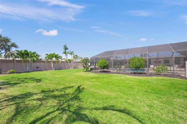 view of yard with glass enclosure and a fenced backyard