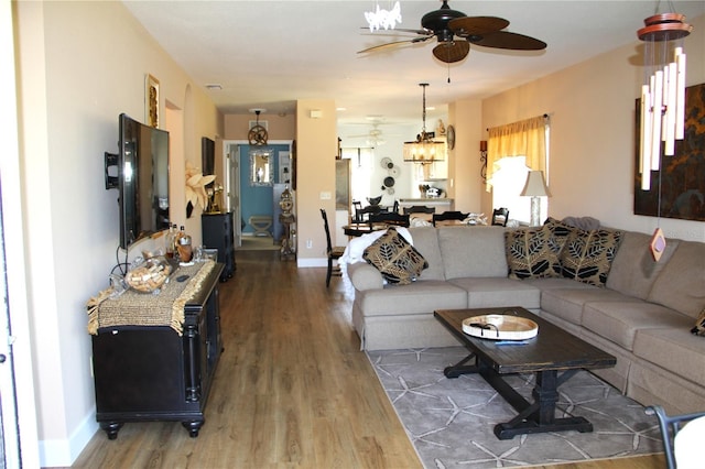 living room featuring wood finished floors, a ceiling fan, and baseboards