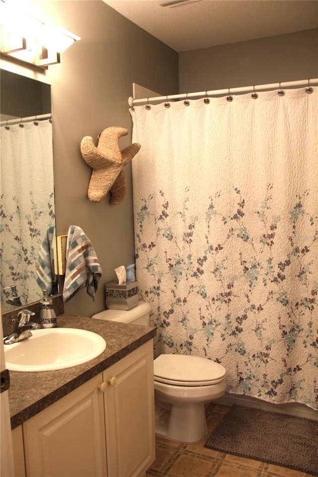 bathroom featuring vanity, toilet, and a shower with curtain