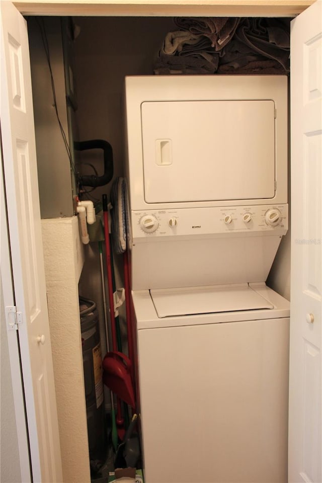 clothes washing area with stacked washer / dryer and laundry area