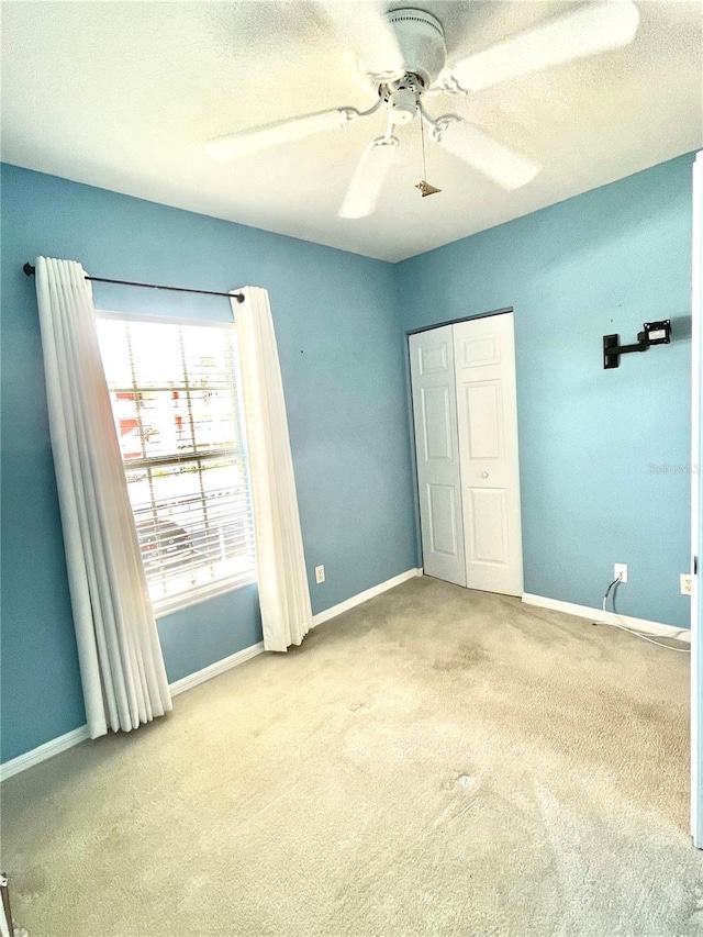 2060 Willow Hammock Cir Unit 201, Punta Gorda, FL 33983 - unfurnished bedroom featuring carpet floors, baseboards, a ceiling fan, and a closet