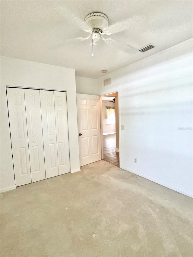 2060 Willow Hammock Cir Unit 201, Punta Gorda, FL 33983 - unfurnished bedroom with carpet floors, a closet, baseboards, and ceiling fan