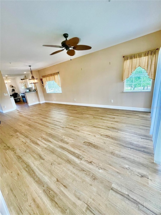 2060 Willow Hammock Cir Unit 201, Punta Gorda, FL 33983 - unfurnished living room with ceiling fan, light wood-style flooring, and baseboards
