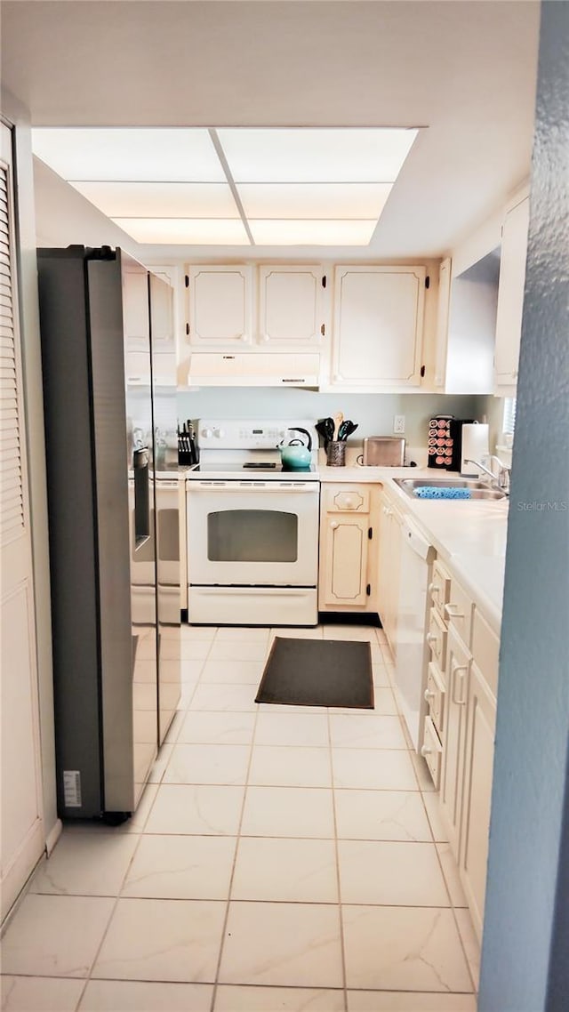 kitchen featuring under cabinet range hood, white appliances, a sink, and light countertops